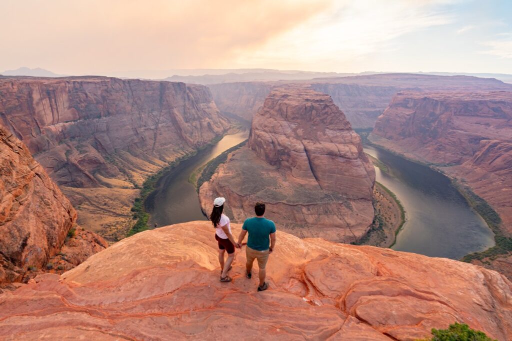 kate storm and jeremy storm holding hands overlooking horseshoe bend arizona