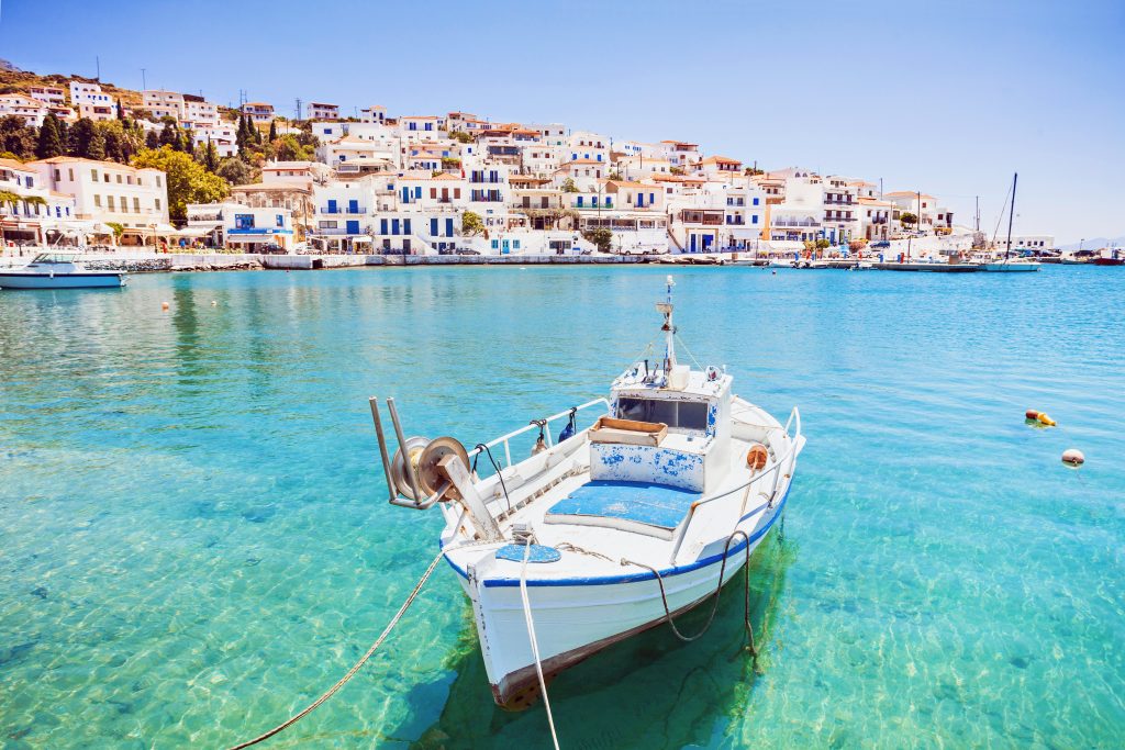 fishing boat in front of a village in greece