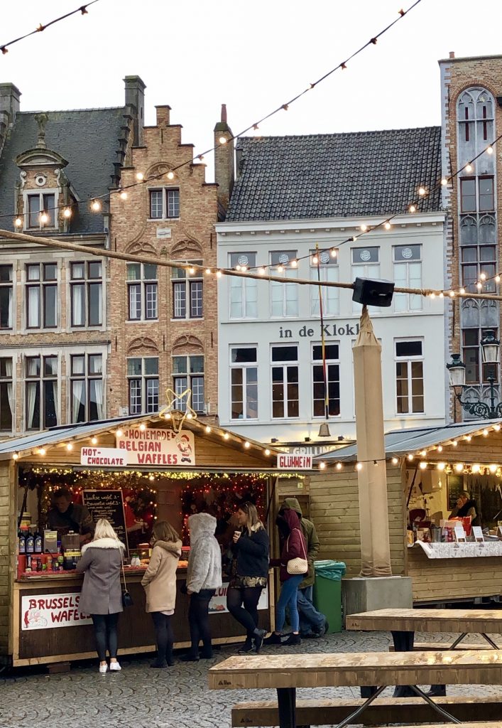 people shopping at a belgium christmas market in bruges