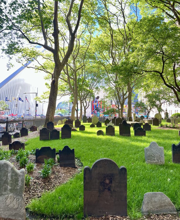 gravestones at st pauls in the nyc financial district with the oculus slightly visible in the background