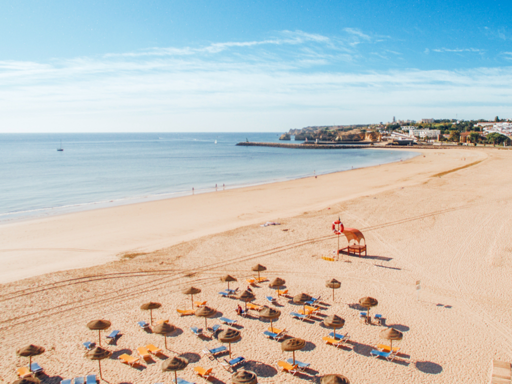 colorful umbrellas on meia praia, one of the best beaches lagos portugal