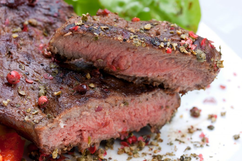 new york strip steak served on a white plate