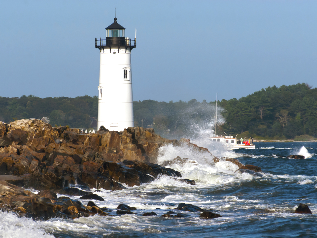 lighthouse in portsmouth new hampshire with waves crashing against rocks