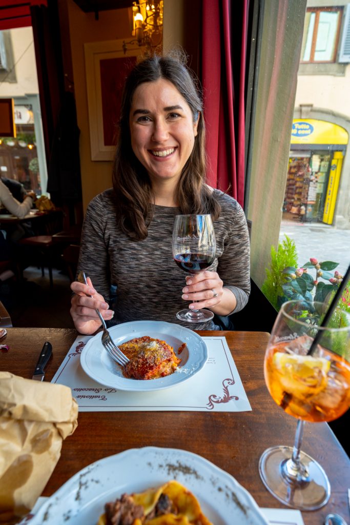 kate storm at a restaurant in florence with lasagna and red wine