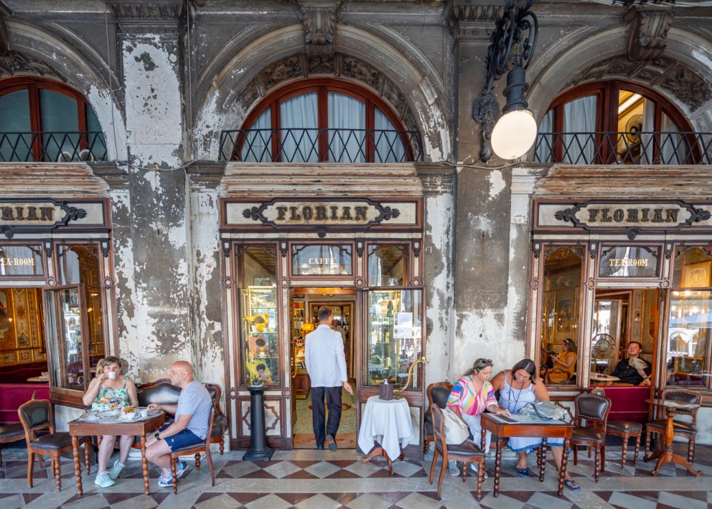 travelers enjoying coffee on the terrace of cafe florian, one of the best photo spots in venice italy