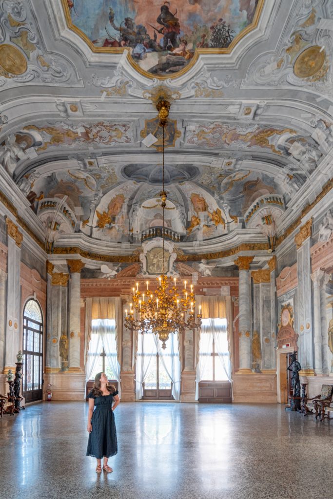 kate storm wearing a black dress in ca' rezzonico, one of the unusual things to do in venice
