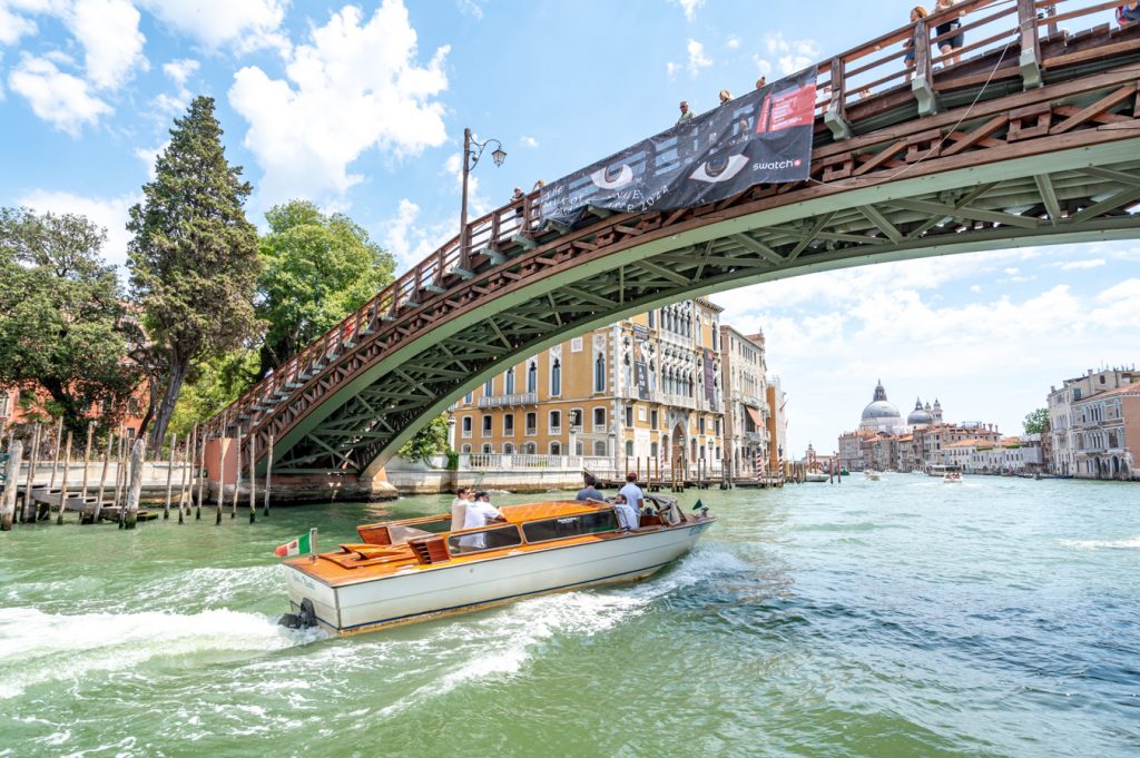 small boat traveling underneath ponte dell accademia on grand canal in venice italy