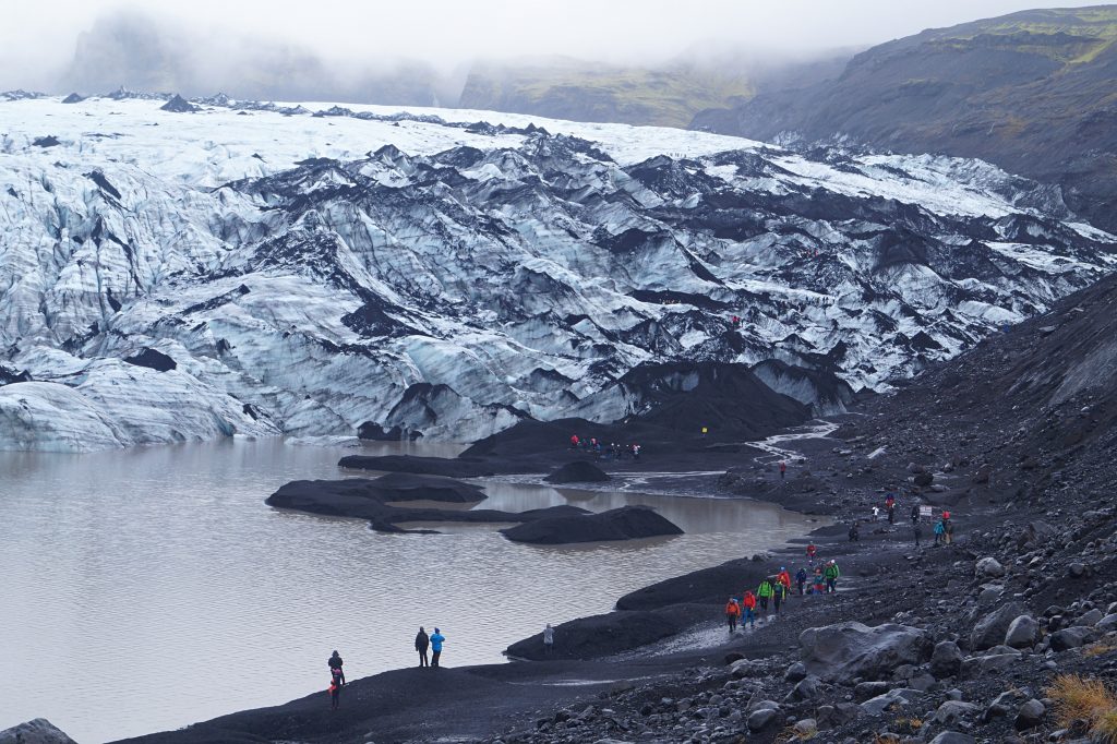 hikers approaching Sólheimajökull glacier in iceland