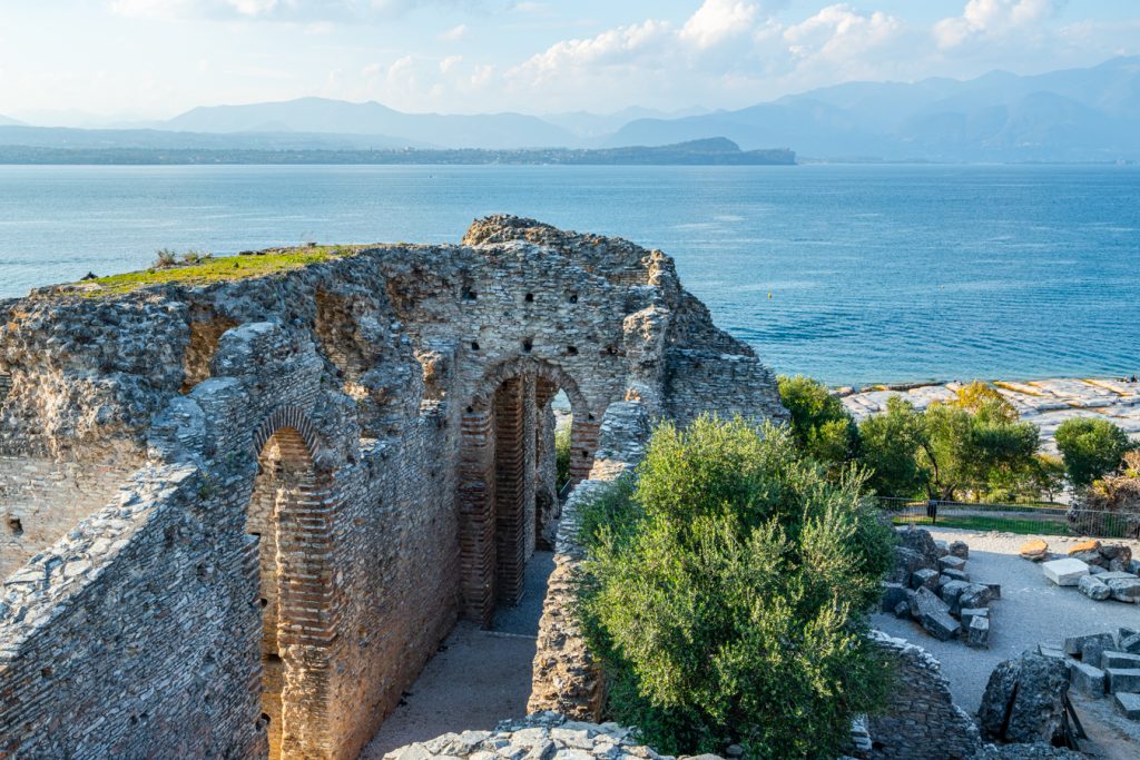 view of a portion of the ruins of grotte di catullo with lake garda in the background, one of the best things to see in sirmione italy
