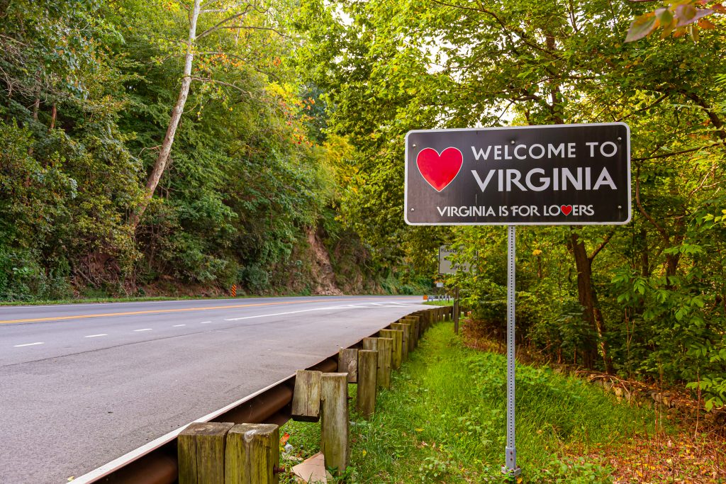 sign reading "welcome to virginia" along a forested road, a common sight when en route to the best virginia vacation spots