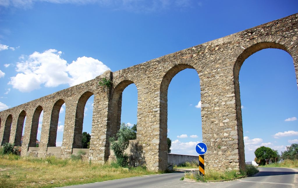 evora portugal aqueduct with paved road running underneath it