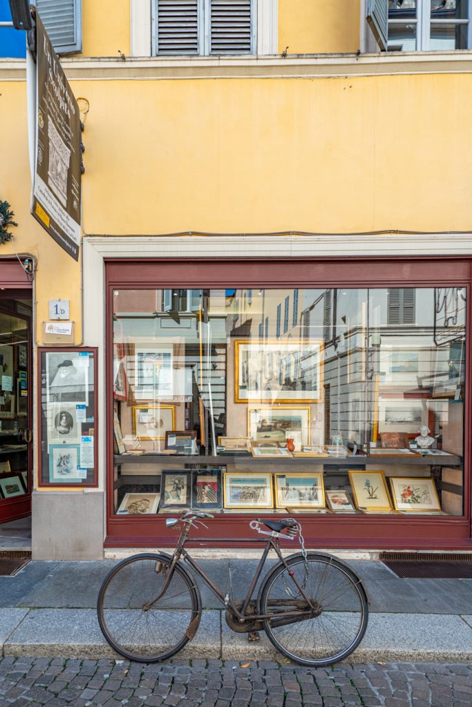 historic center of parma italy with a bike parked in front of an antique book and art store