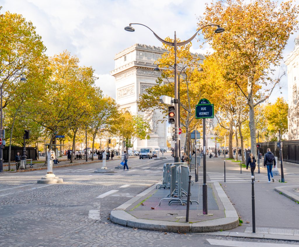 view of arc de triomphe in the distance as seen from a side street with fall foliage in the foreground