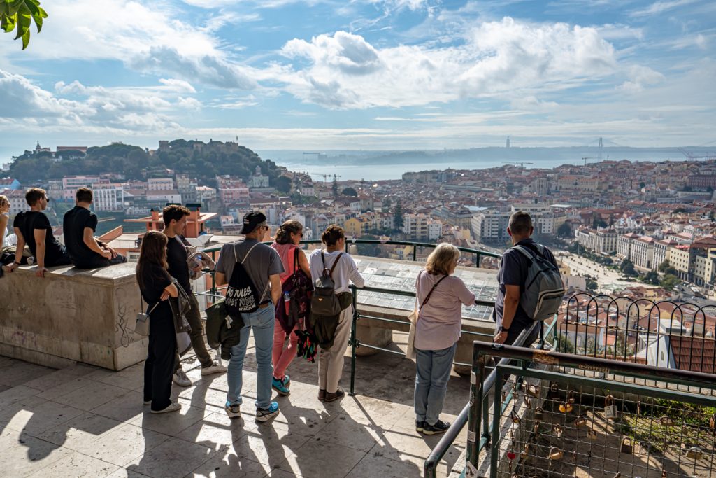 group of travelers admiring lisbon from the miradouro senhora do monte, one of the most beautiful views in lisbon portugal