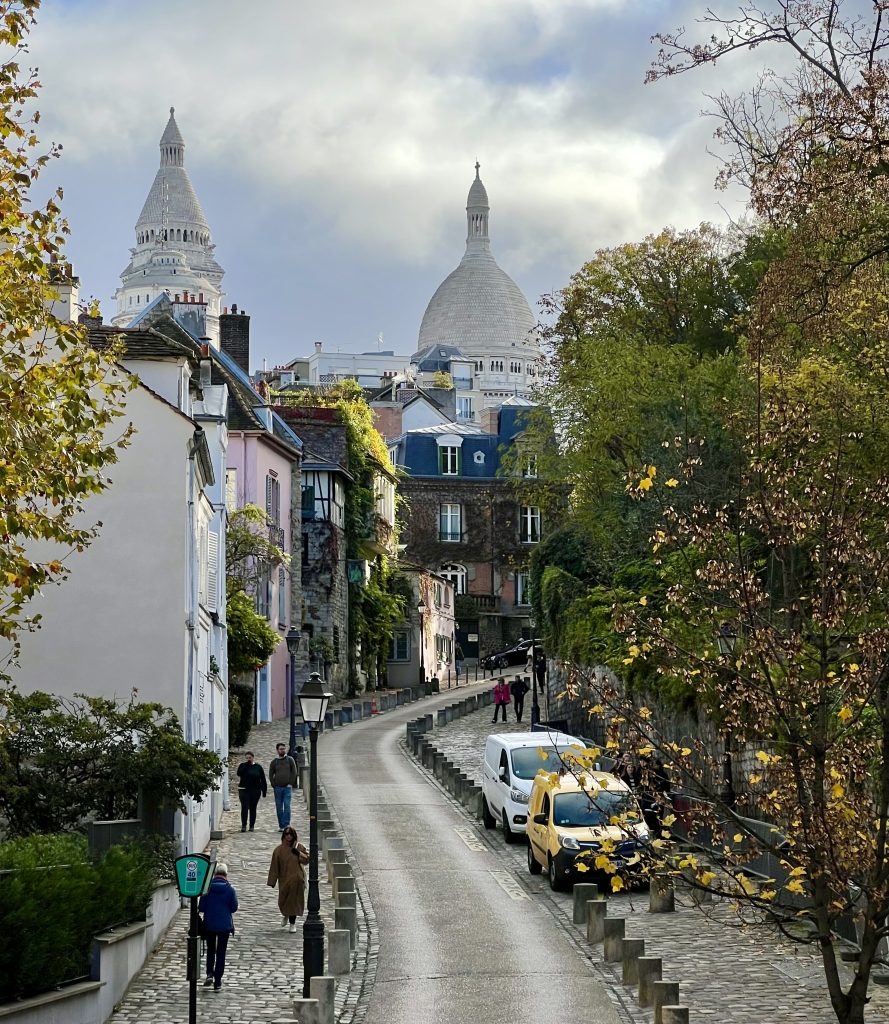 view of rue de l'abreuvoir and sacre coeur domes from place dalida montmartre