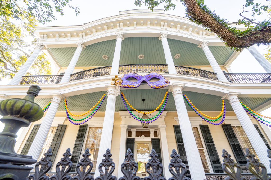 front facade of a white home in the garden district of new orleans in january decorated for mardi gras