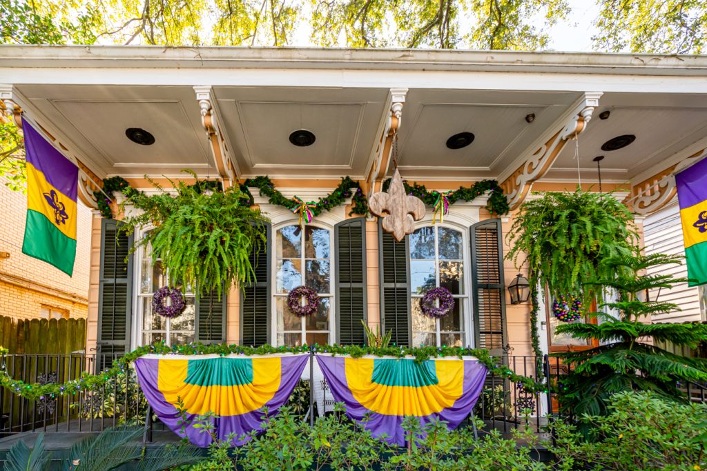 front facade of a new orleans garden district home decorated for mardi gras