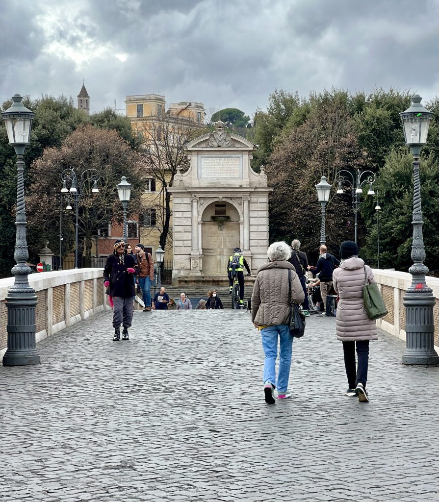 view of people walking toward trastevere piazza trilussa on ponte sisto
