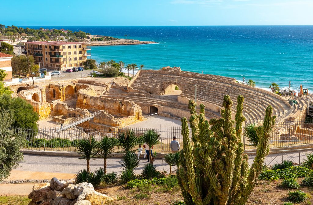 view of roman amphitheater in tarrgona spain with mediterranean sea in the distance