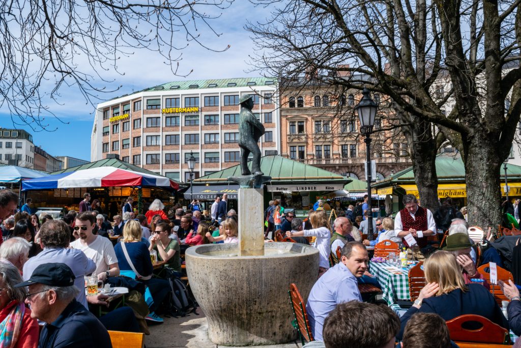 crowds of people enjoying Viktualienmarkt beer garden in the spring in munich germany