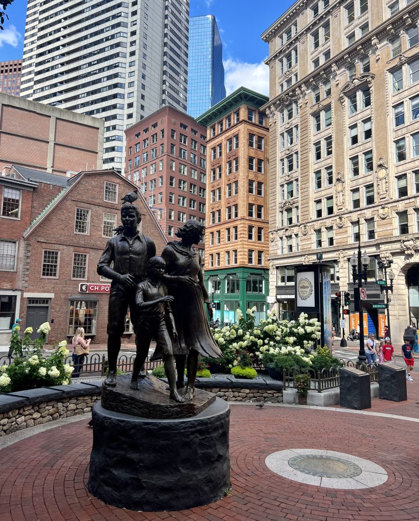 irish famine memorial in boston with old corner bookstore visible behind it, one of the best places to visit in boston in 24 hours