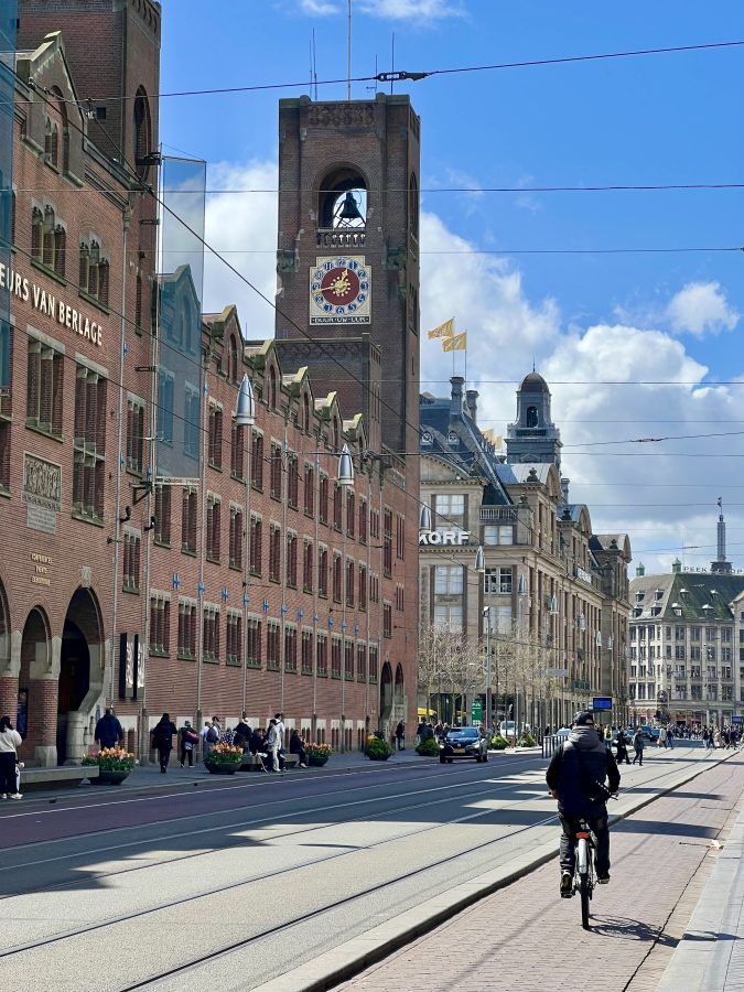 main street in amstedam with man riding a bike down the center