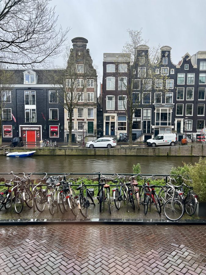 cloudy skies with bikes parked in front of a canal on a rainy day in amsterdam april