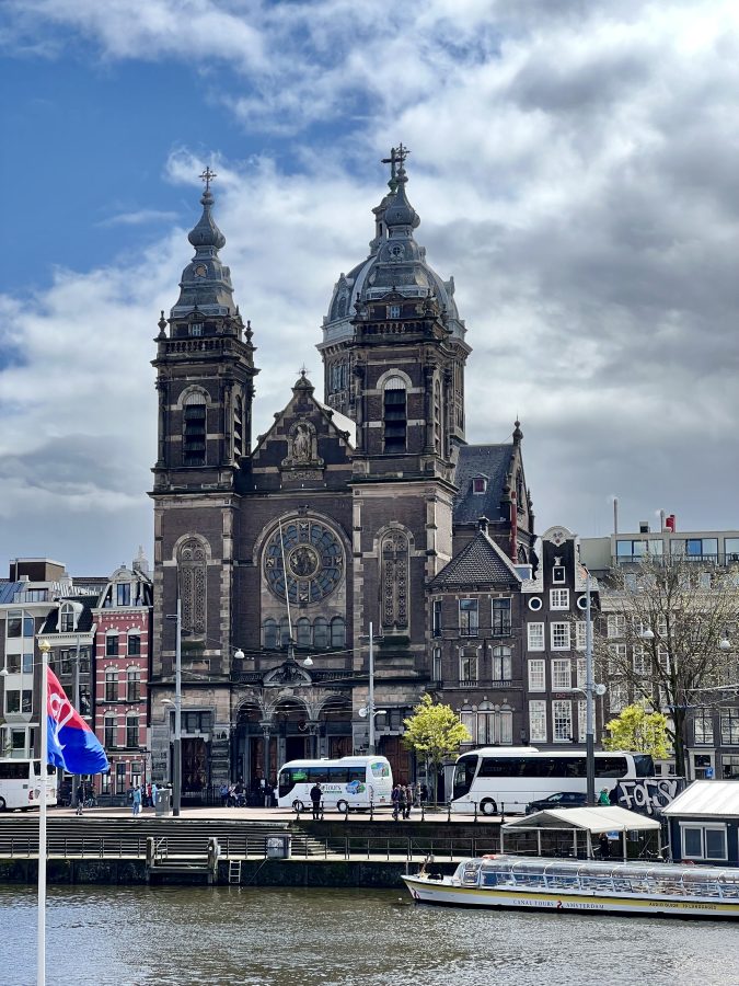 front facade of a church in amsterdam in april with canal visible in the foreground