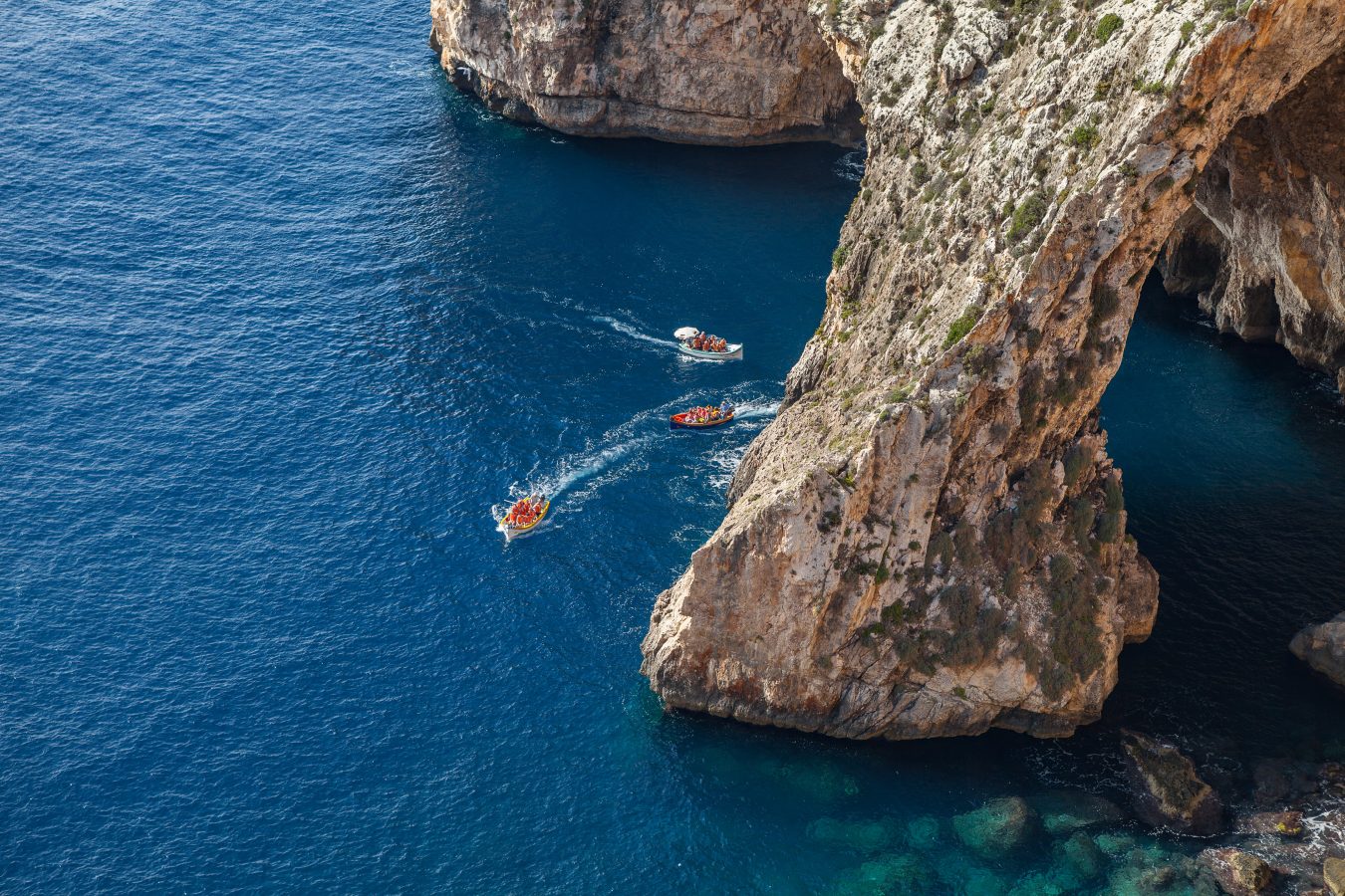 view of a few boats near the blue grotto in malta as seen from above