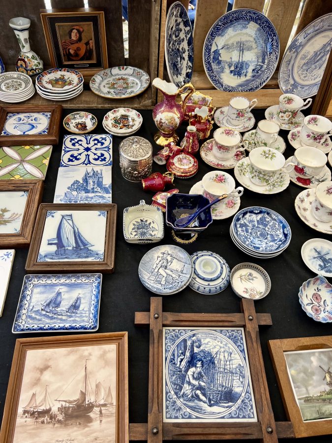 delftware and other netherlands souvenirs for sale on a table at the delft flea market