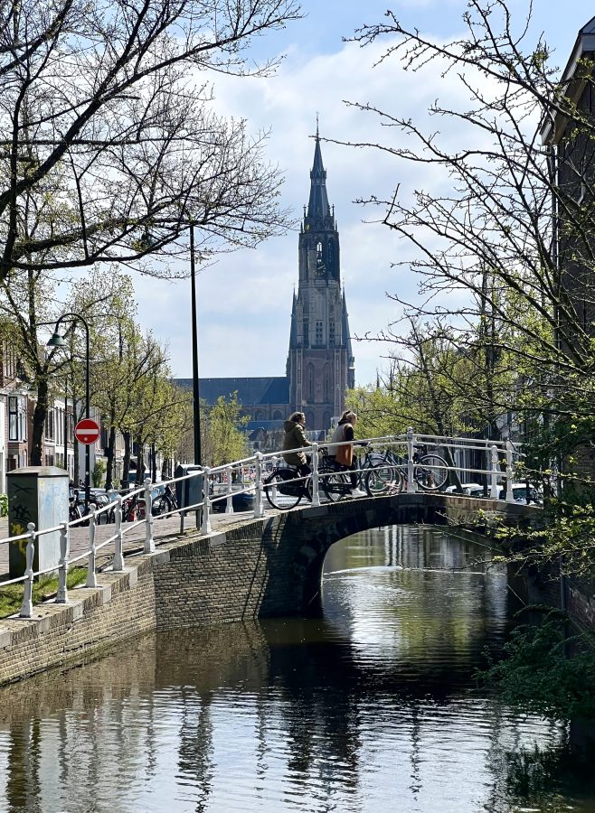 view of delft kerk tower from across a canal