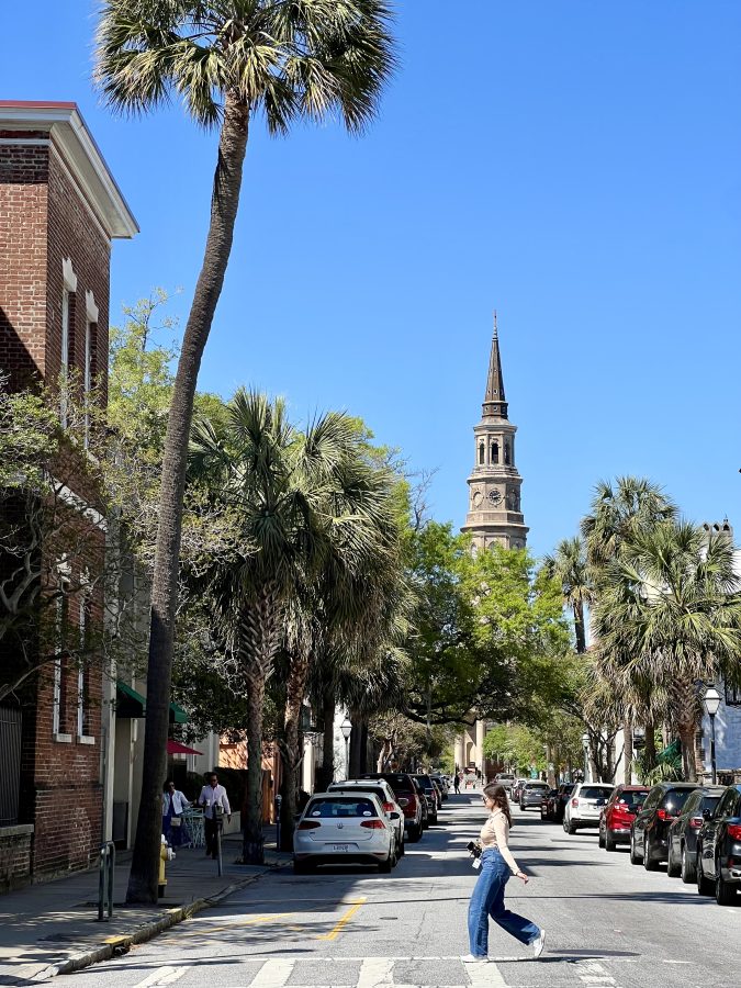 view of st philips church in charleston sc from church street, with a woman crossing the street in the foreground of the photo