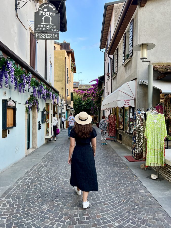 kate storm in a black dress and straw hat walking to dinner when visiting sirmione italy