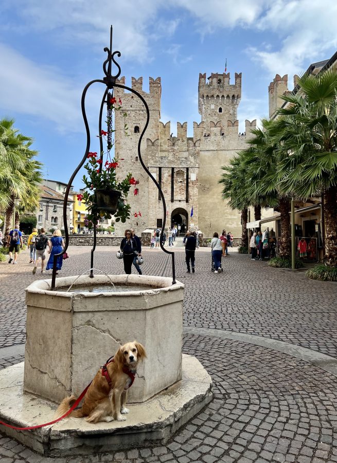 ranger storm in front of a stone well in sirmione italy, with castello scaligero visible in the background