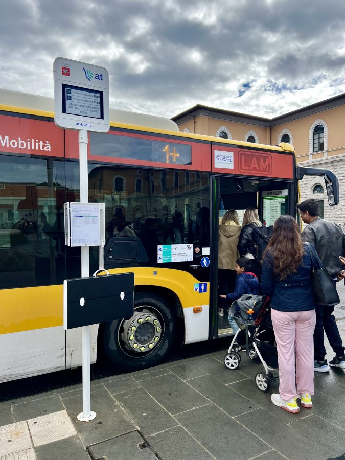 picture of travelers lined up to board bus from pisa centrale to piazza dei miracoli on a cloudy day