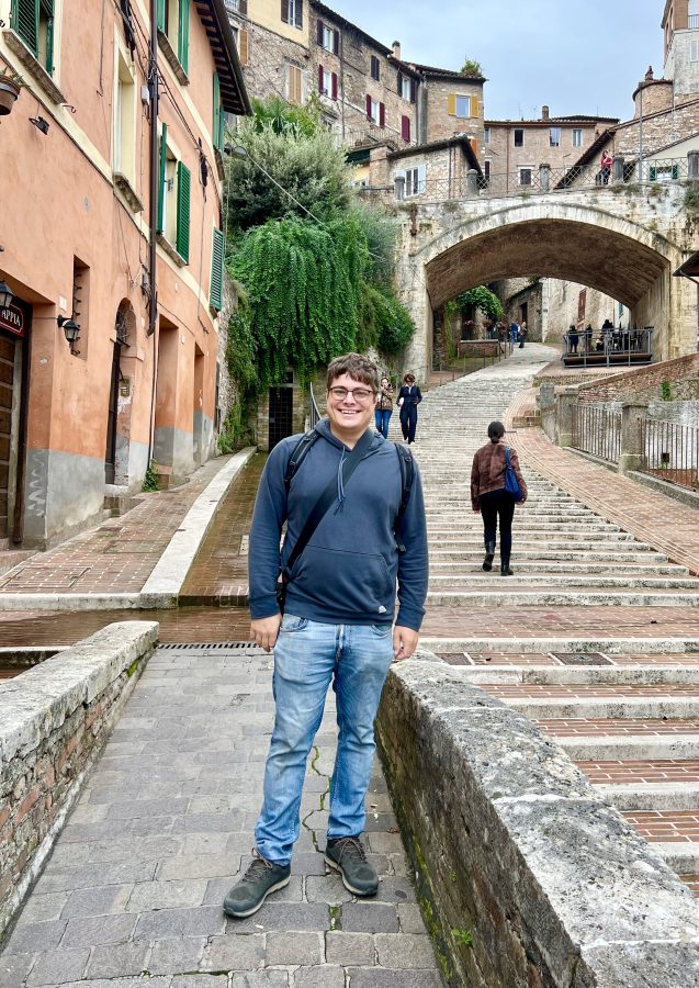jeremy storm standing on perugia medieval aqueduct with bridge in the background