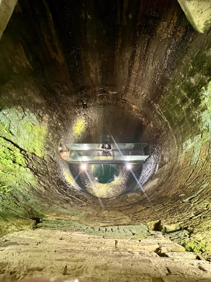 kate storm and her baby on the transparent bridge inside the etruscan well, one of the best things to do in perugia italy