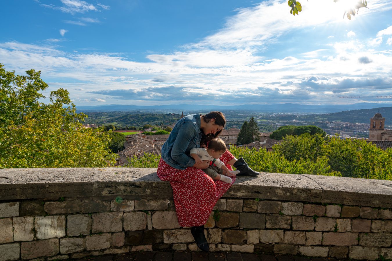 kate storm in a red skirt with her baby at the edge of giardini cartucci, one of the best things to see in perugia umbria