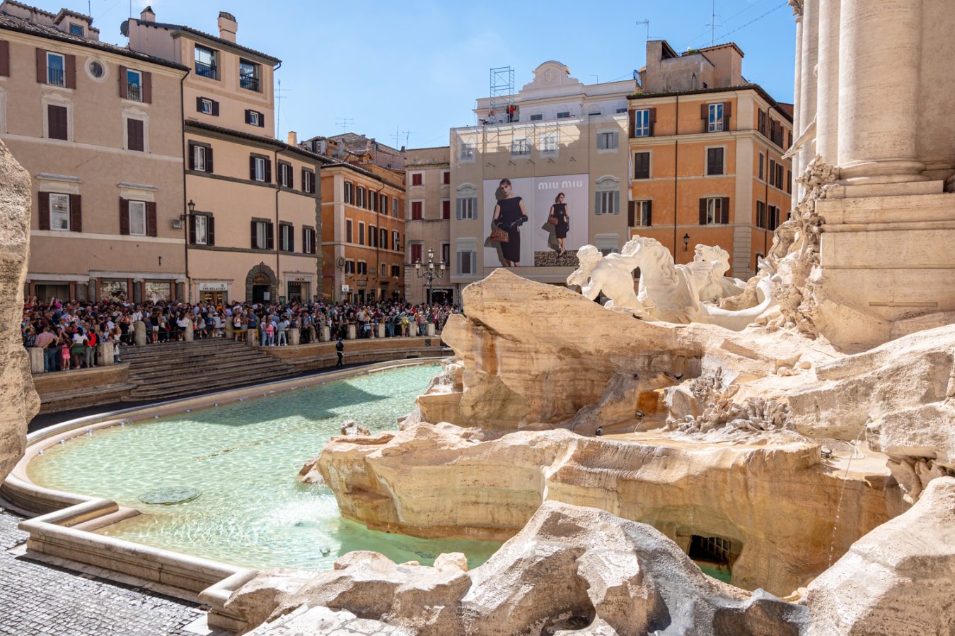 the trevi fountain in italy as seen from a back corner and looking out toward the crowd, an excellent stop during a week in italy