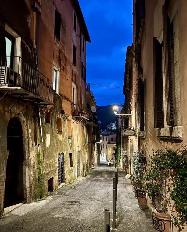 quiet street in tivoli italy at blue hour with street lights on