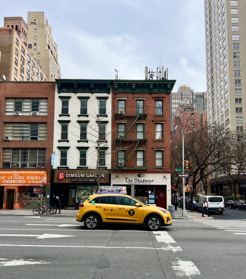 yellow nyc taxi stopped at an uncrowded intersection in manhattan
